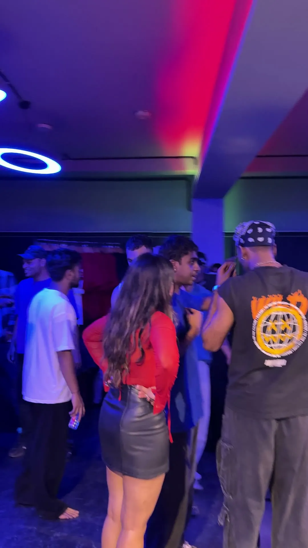 Dancers gathered in a circle on the ORBYT floor under blue and red light