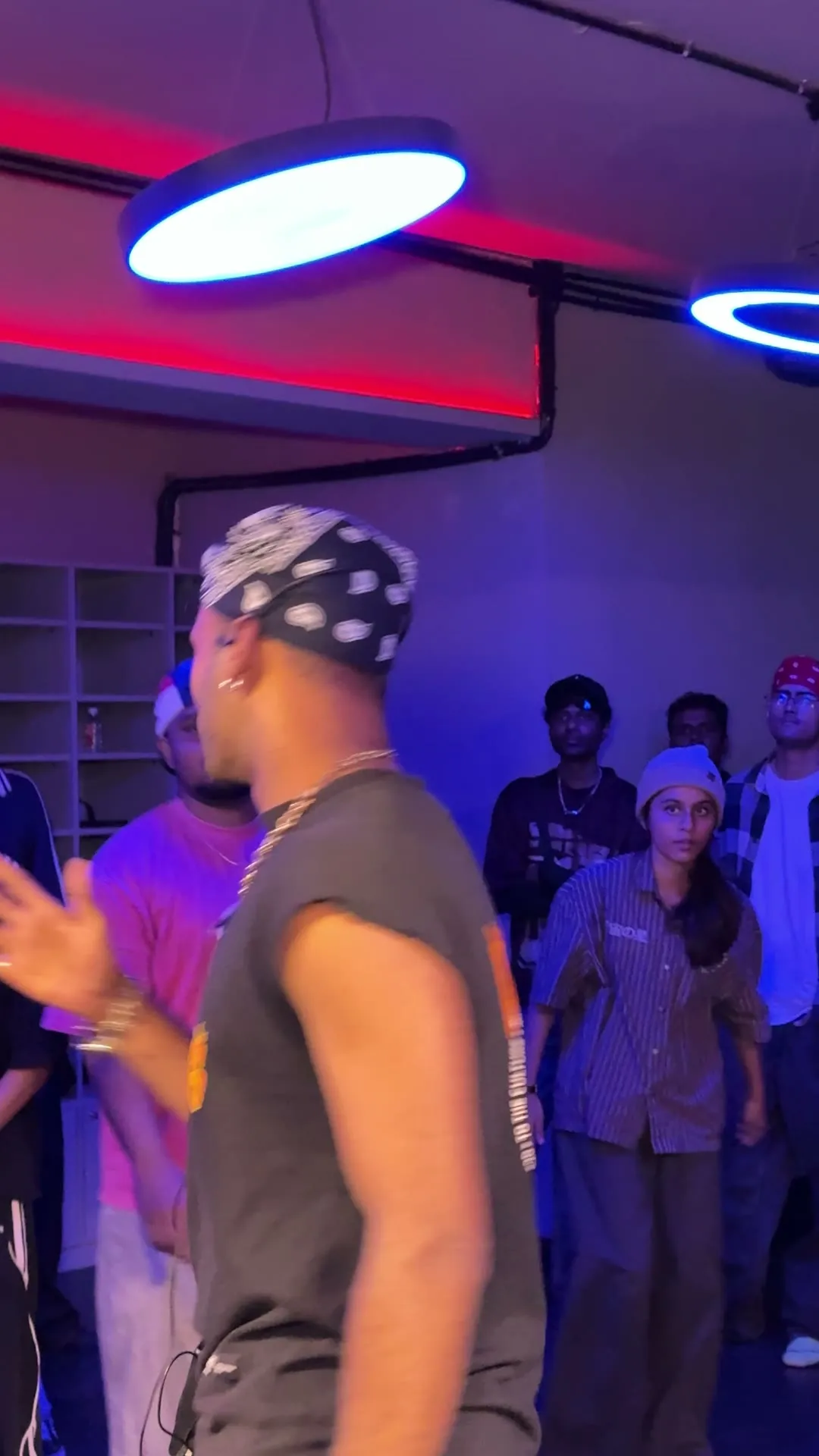 The crowd hyping a dancer in an orange-print vest